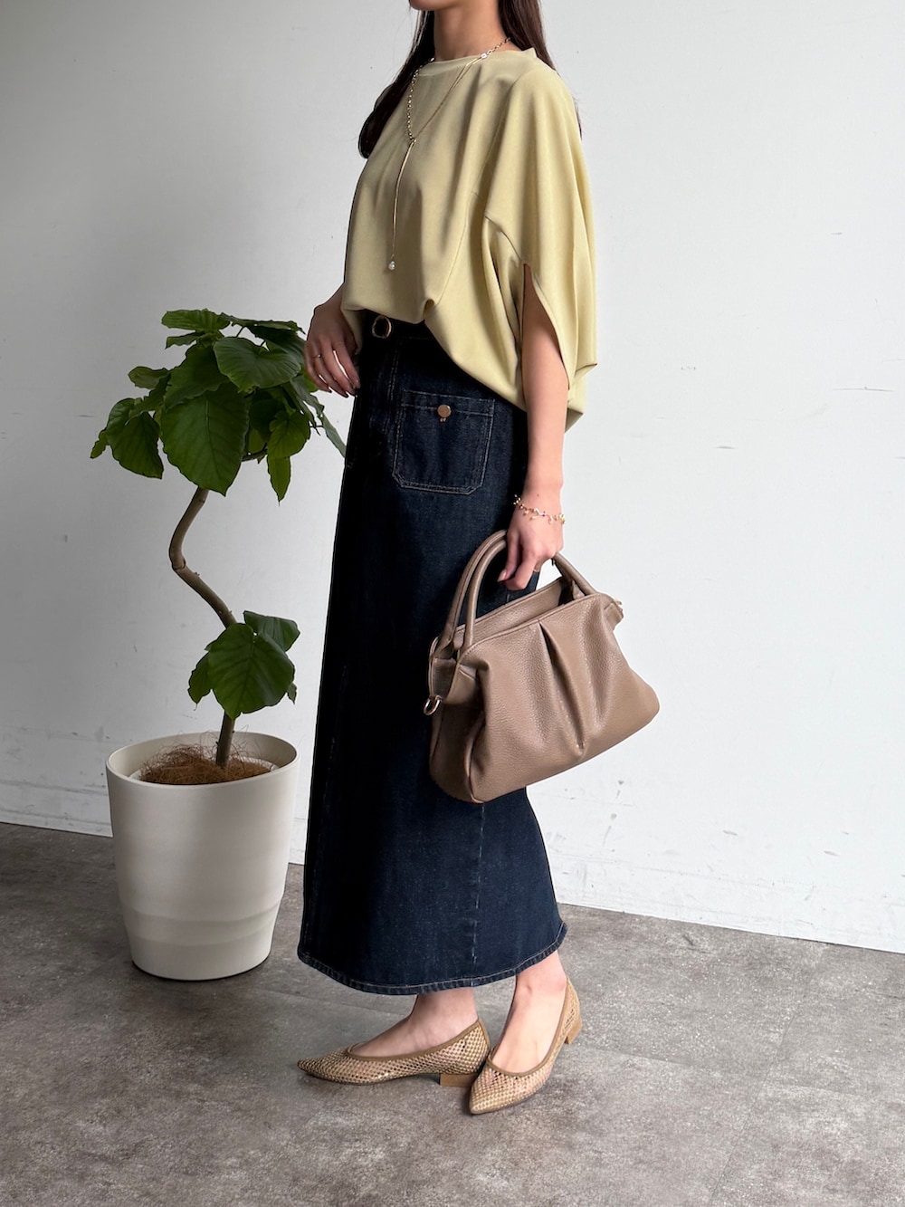 グリーン系のTシャツ/カットソー、ブルー系のスカート、ベージュ系のボストンバッグを着用したレディースの春コーディネートの2枚目の写真
