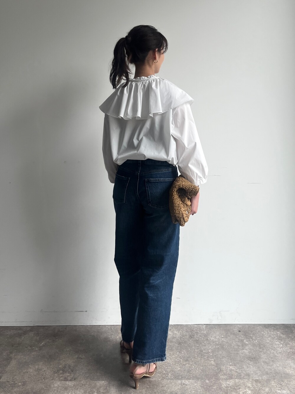 ホワイト系のシャツ/ブラウス、ブルー系のデニムパンツ、ブラウン系のサンダルを着用したレディースの春コーディネートの2枚目の写真