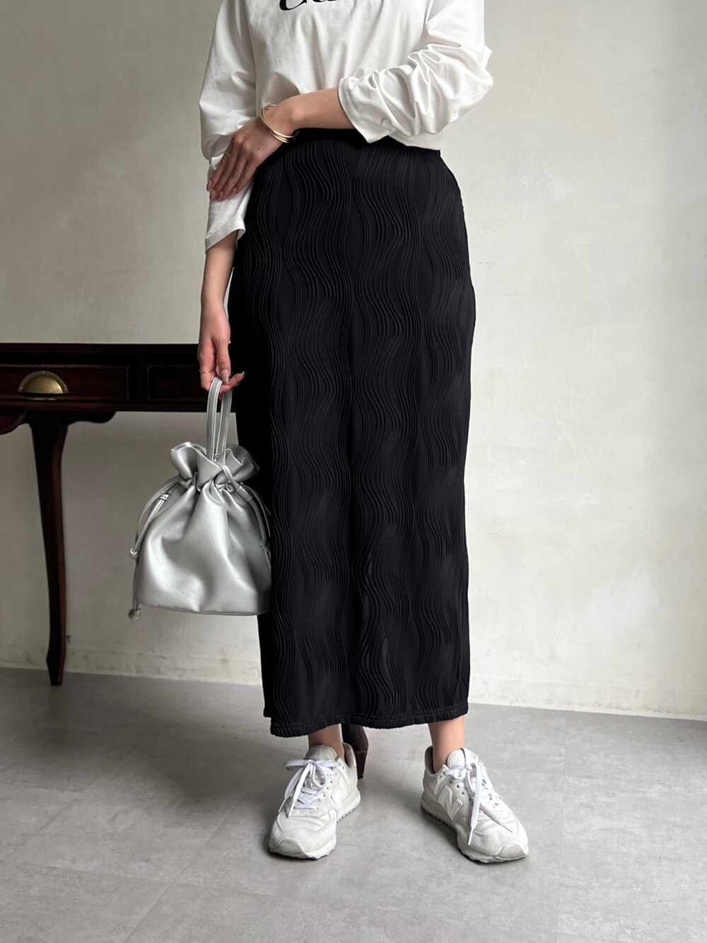 ホワイト系のTシャツ/カットソー、ブラック系のスカート、シルバー系のショルダーバッグを着用したレディースの春コーディネートの3枚目の写真