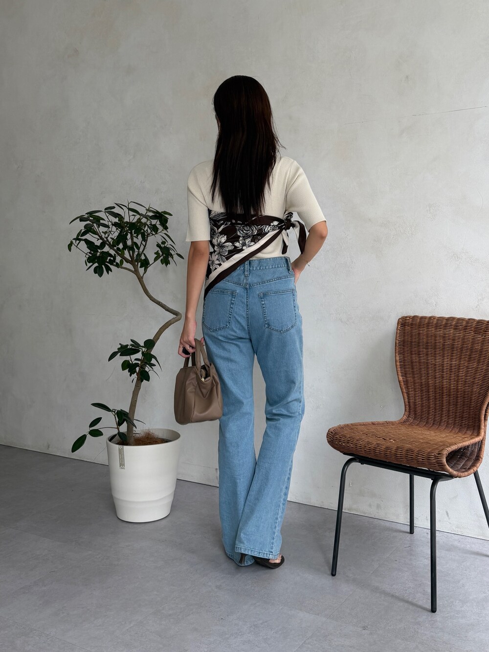 ベージュ系のボストンバッグ、ブルー系のデニムパンツ、ホワイト系のニット/セーターを着用したレディースの夏コーディネートの5枚目の写真