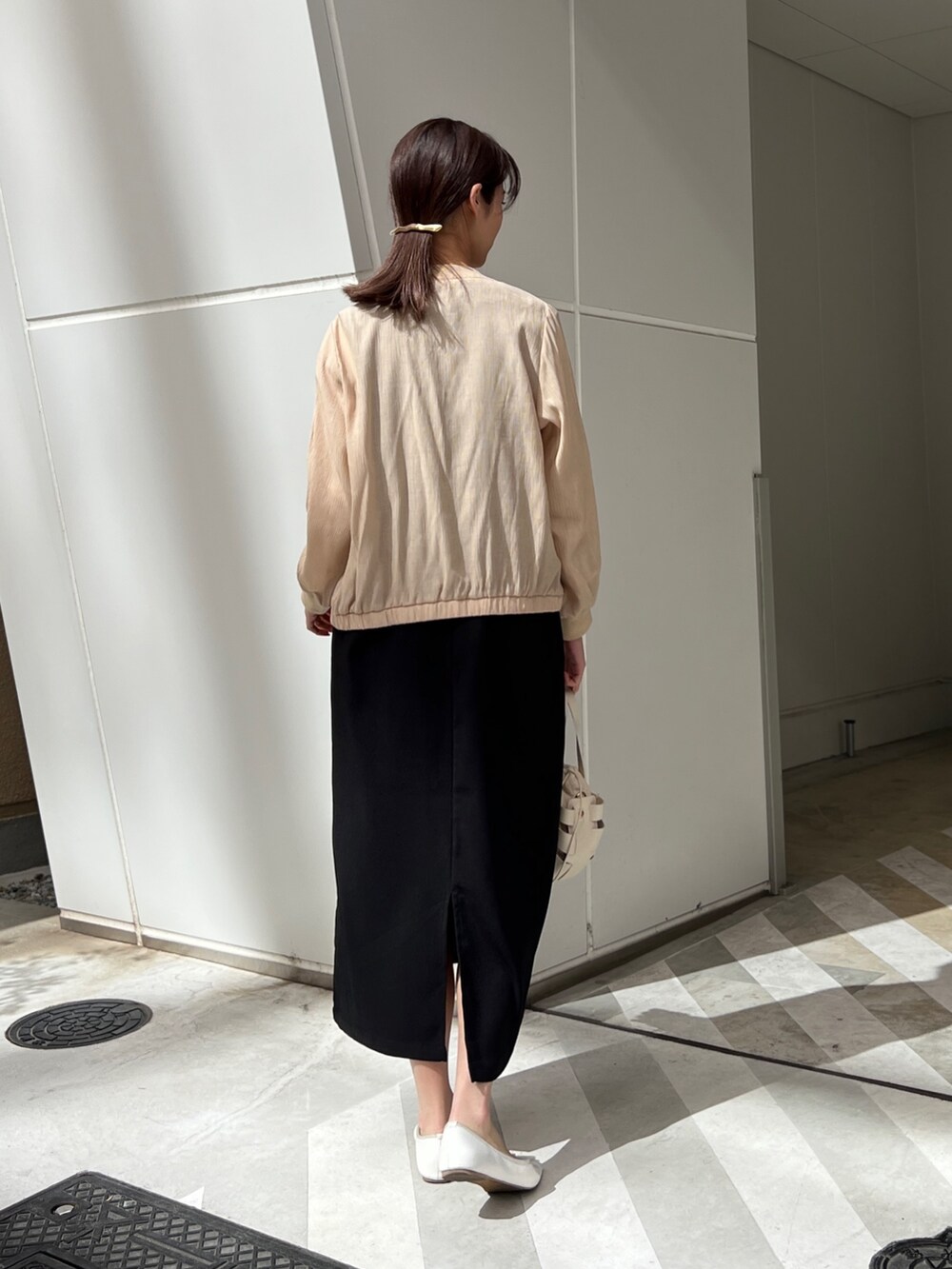 ベージュ系のジャケット/アウター、ブラック系のワンピース、ホワイト系のショルダーバッグを着用したレディースの春コーディネートの2枚目の写真