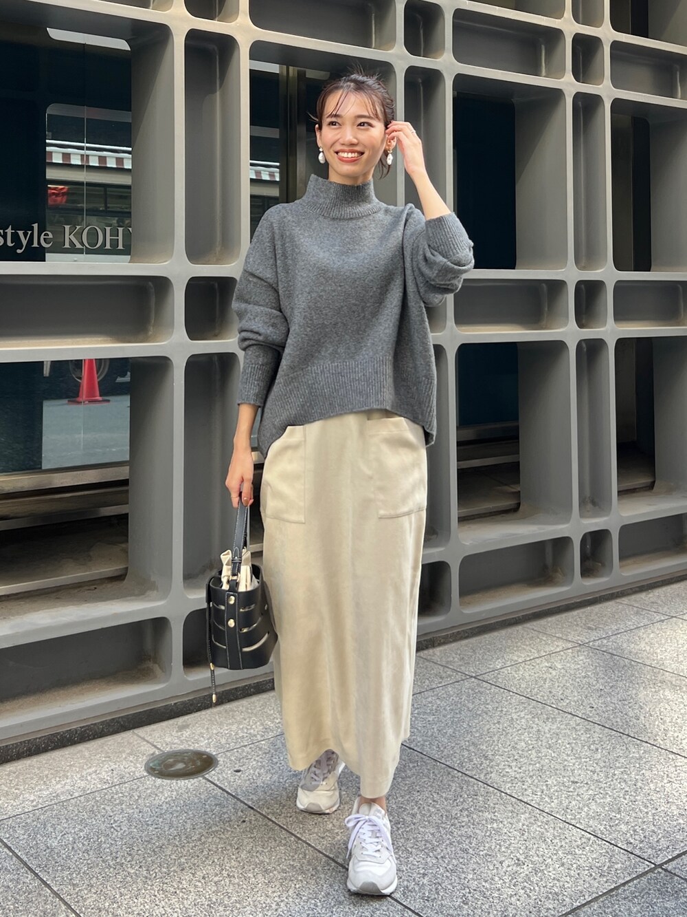 グリーン系のその他アウター、グレー系のニット/セーター、ホワイト系のスカートを着用したレディースの秋コーディネートの2枚目の写真