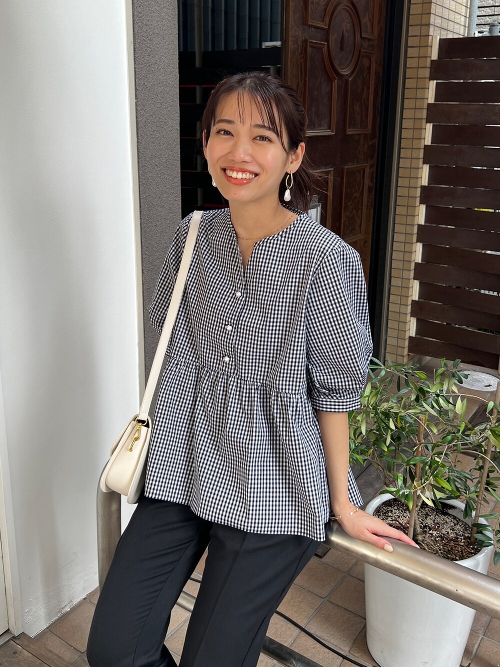 ブラック系のシャツ/ブラウス、ブラック系のその他パンツ、ホワイト系のサンダルを着用したレディースの夏コーディネートの2枚目の写真