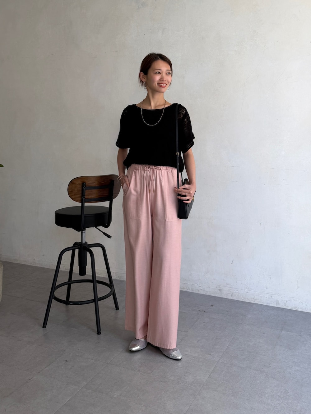 ブラック系のニット/セーター、ピンク系のデニムパンツ、その他のその他を着用したレディースの春コーディネートの2枚目の写真