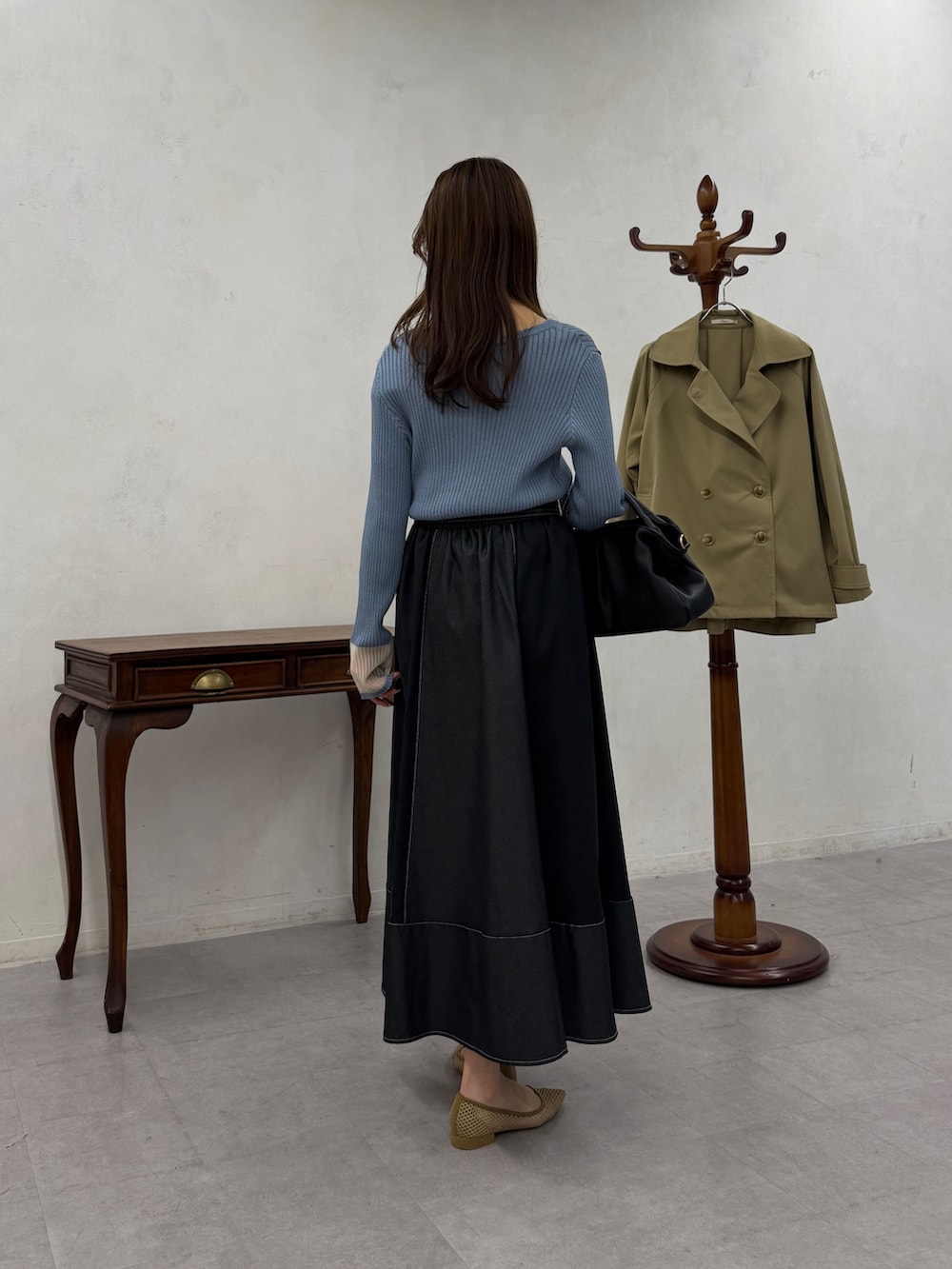 ブルー系のニット/セーター、ブラック系のスカートを着用したレディースの春コーディネートの3枚目の写真