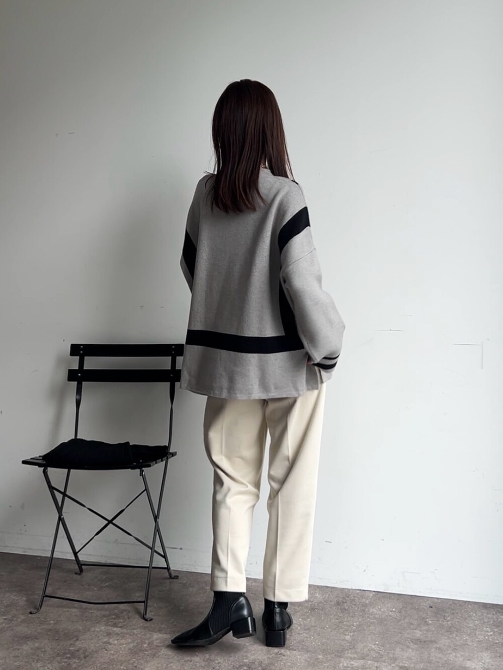 グレー系のニット/セーター、ホワイト系のその他パンツ、ブラック系のブーツを着用したレディースの秋コーディネートの4枚目の写真