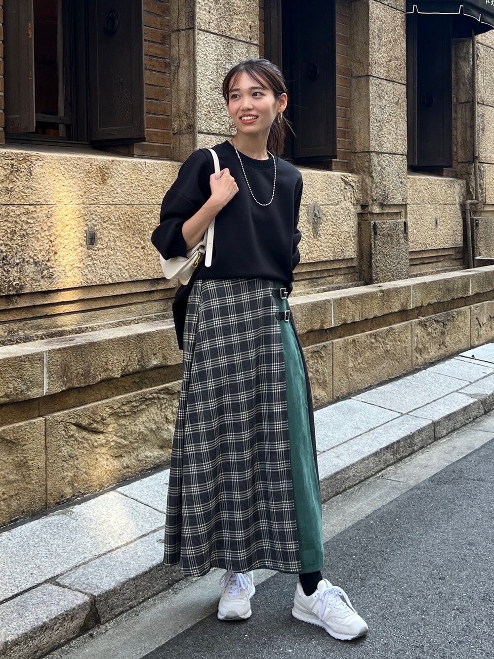 ブラック系のTシャツ/カットソー、ブラック系のスカート、ホワイト系のスニーカーを着用したレディースの秋コーディネートの3枚目の写真