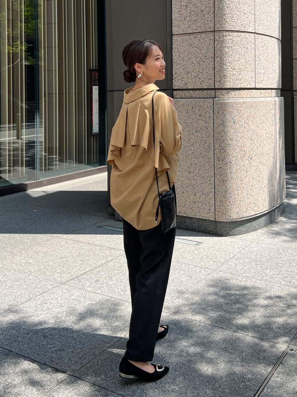 イエロー系のシャツ/ブラウス、ブラック系のその他パンツ、ブラック系のパンプスを着用したレディースの秋コーディネートの2枚目の写真