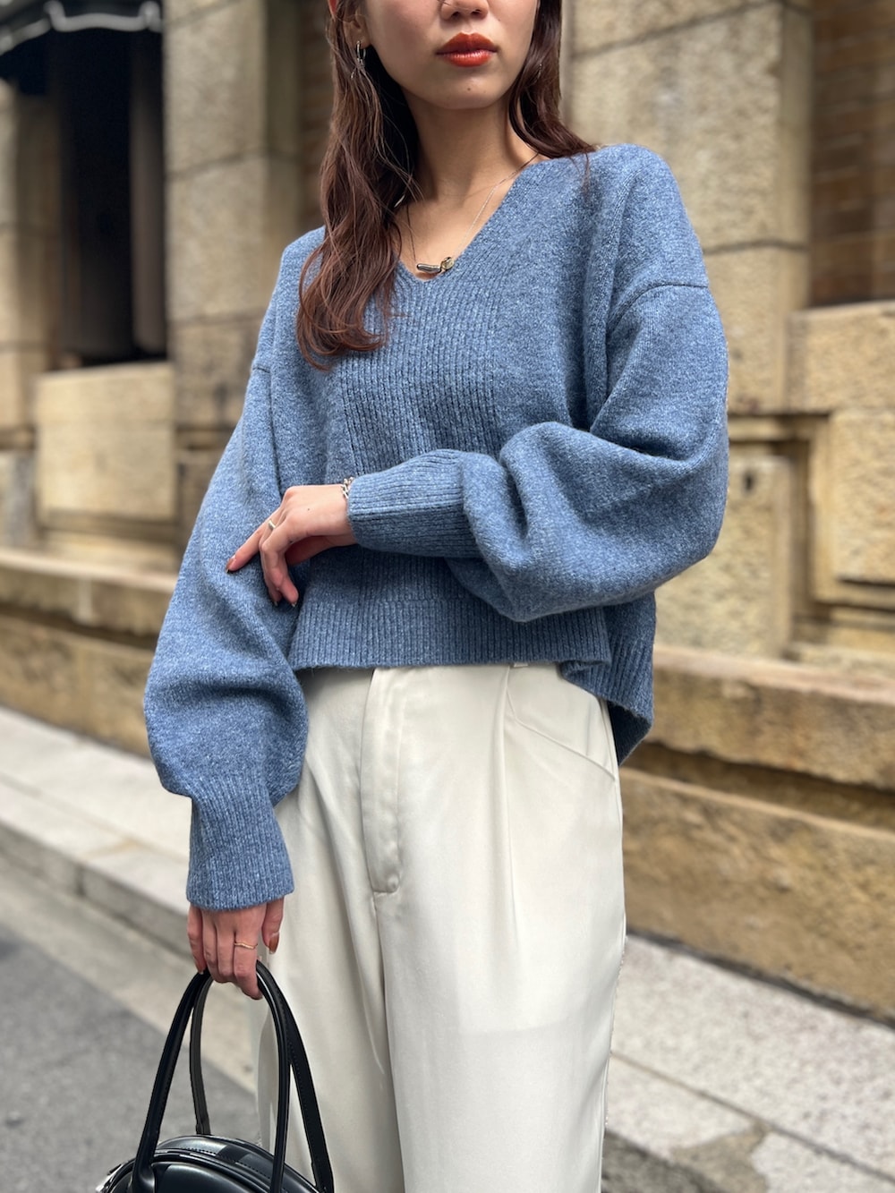 ブルー系のニット/セーター、ブラック系のトートバッグ、ホワイト系のその他パンツを着用したレディースの冬コーディネートの3枚目の写真