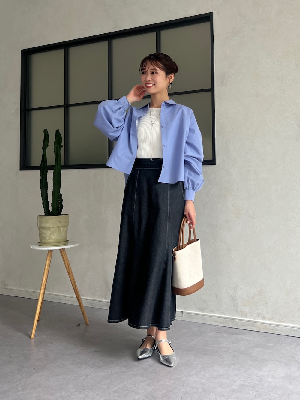 ブルー系のシャツ/ブラウス、ホワイト系のニット/セーター、ブラック系のスカートを着用したレディースの春コーディネートの4枚目の写真