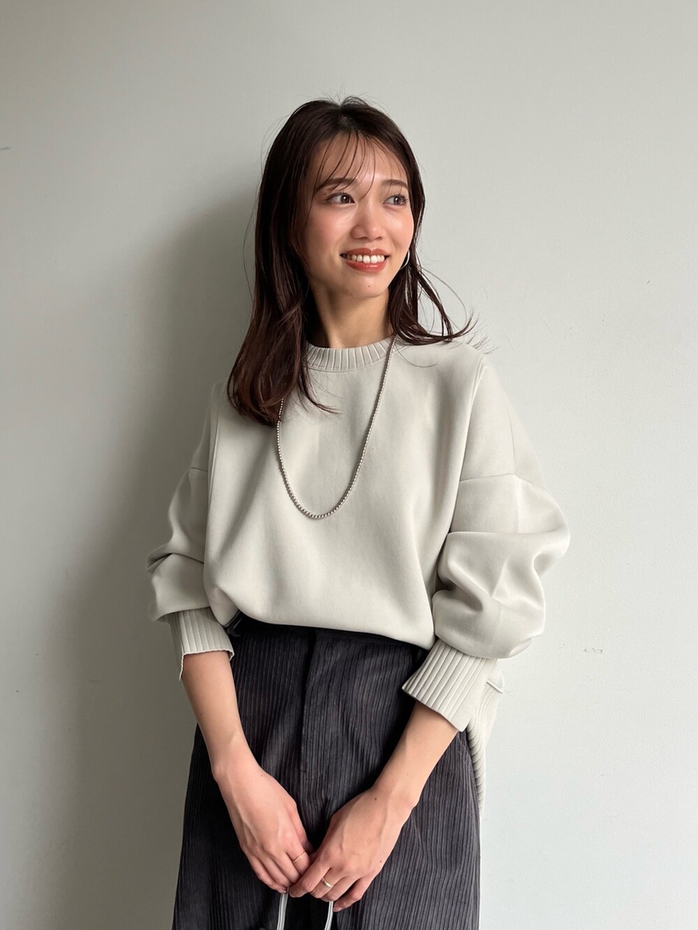 ホワイト系のTシャツ/カットソー、グレー系のスカート、シルバー系のショルダーバッグを着用したレディースの冬コーディネートの3枚目の写真