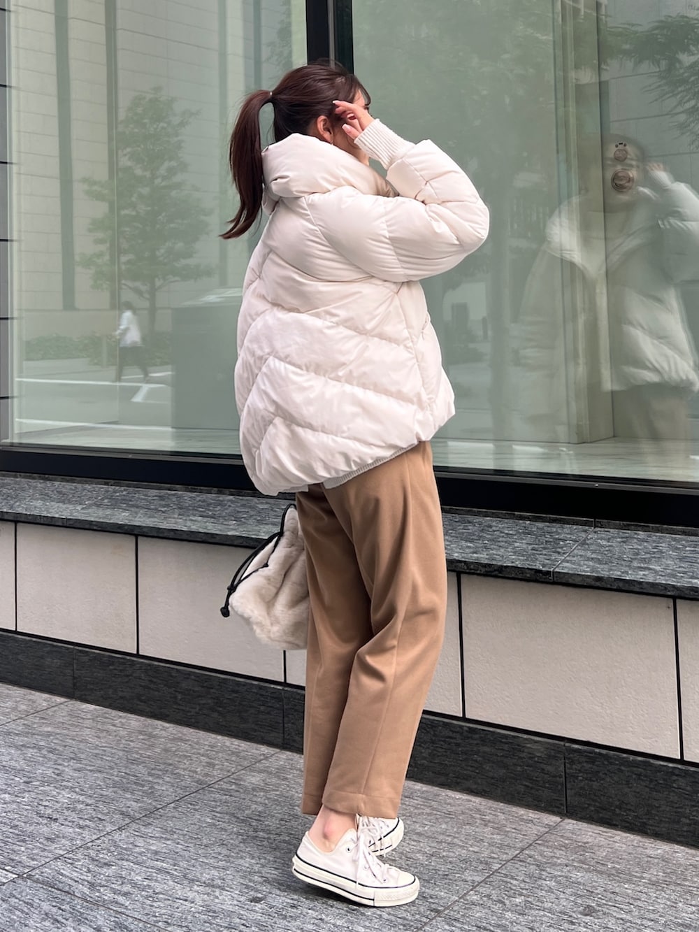 ホワイト系のダウンジャケット/コート、ホワイト系のニット/セーター、ベージュ系のその他パンツを着用したレディースの秋コーディネートの3枚目の写真
