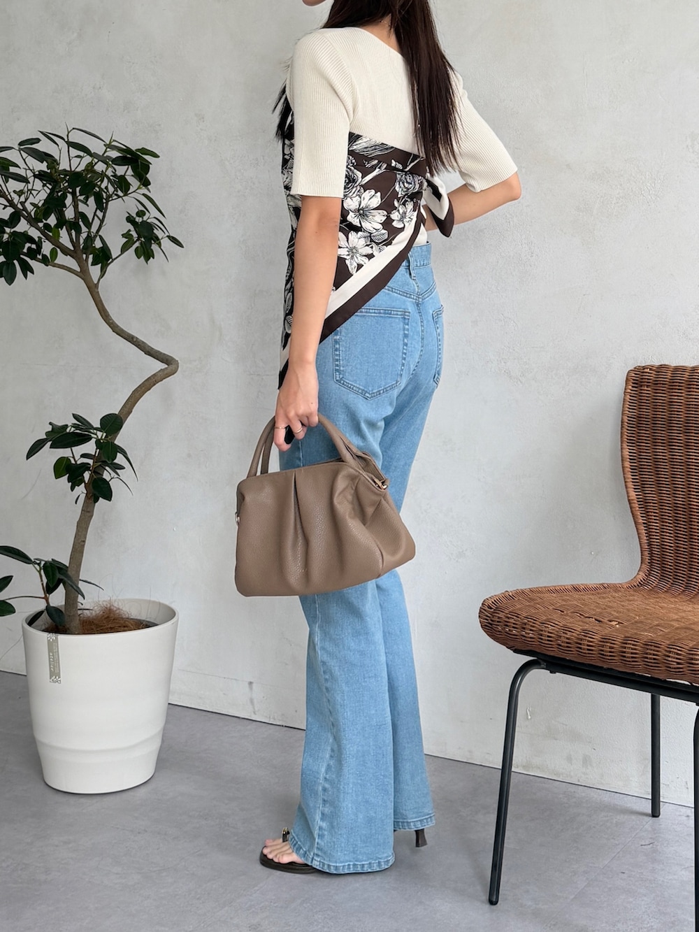 ベージュ系のボストンバッグ、ブルー系のデニムパンツ、ホワイト系のニット/セーターを着用したレディースの夏コーディネートの4枚目の写真