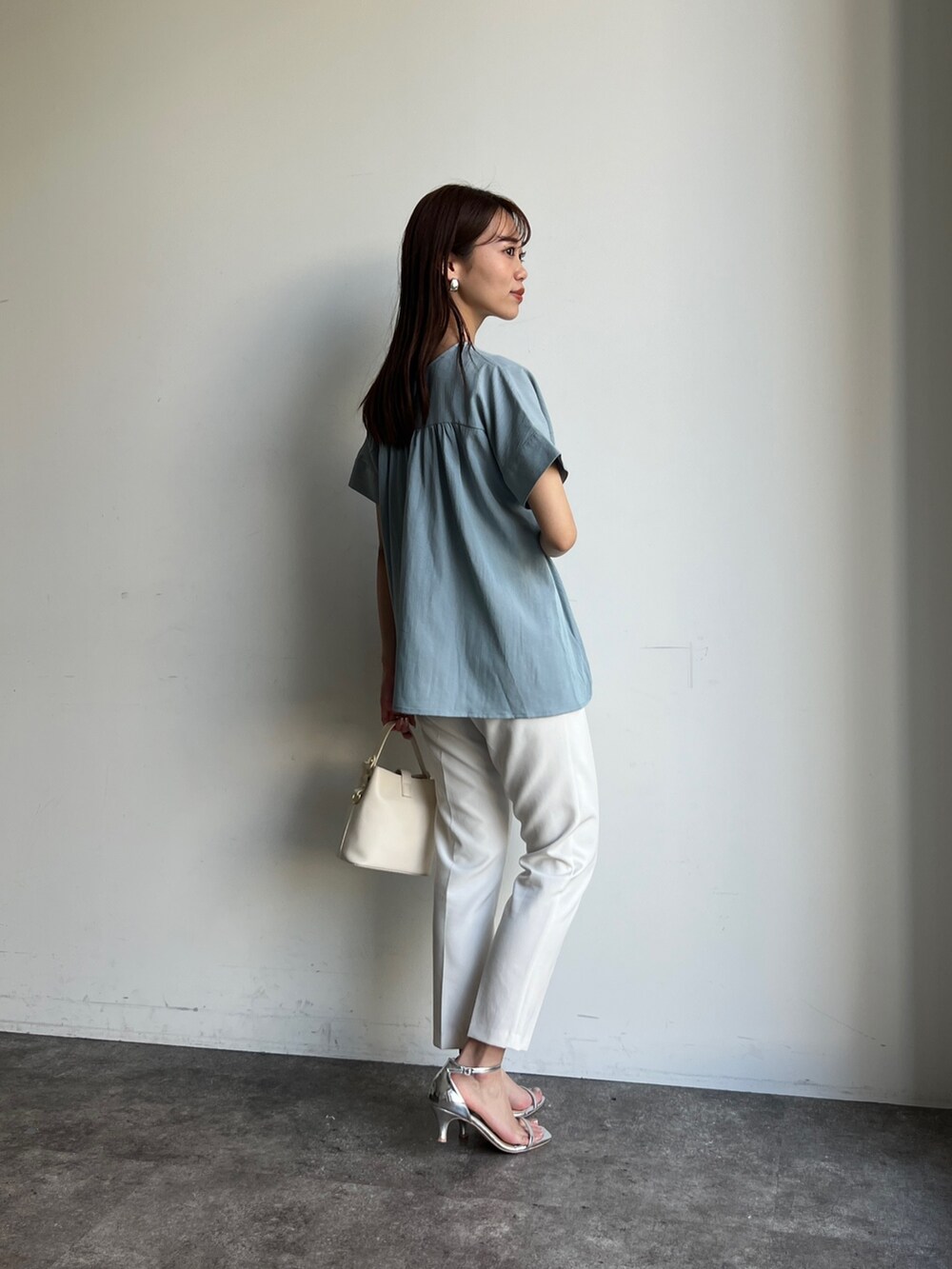 ブルー系のシャツ/ブラウス、ホワイト系のパンツ、シルバー系のシューズを着用したレディースの春コーディネートの2枚目の写真