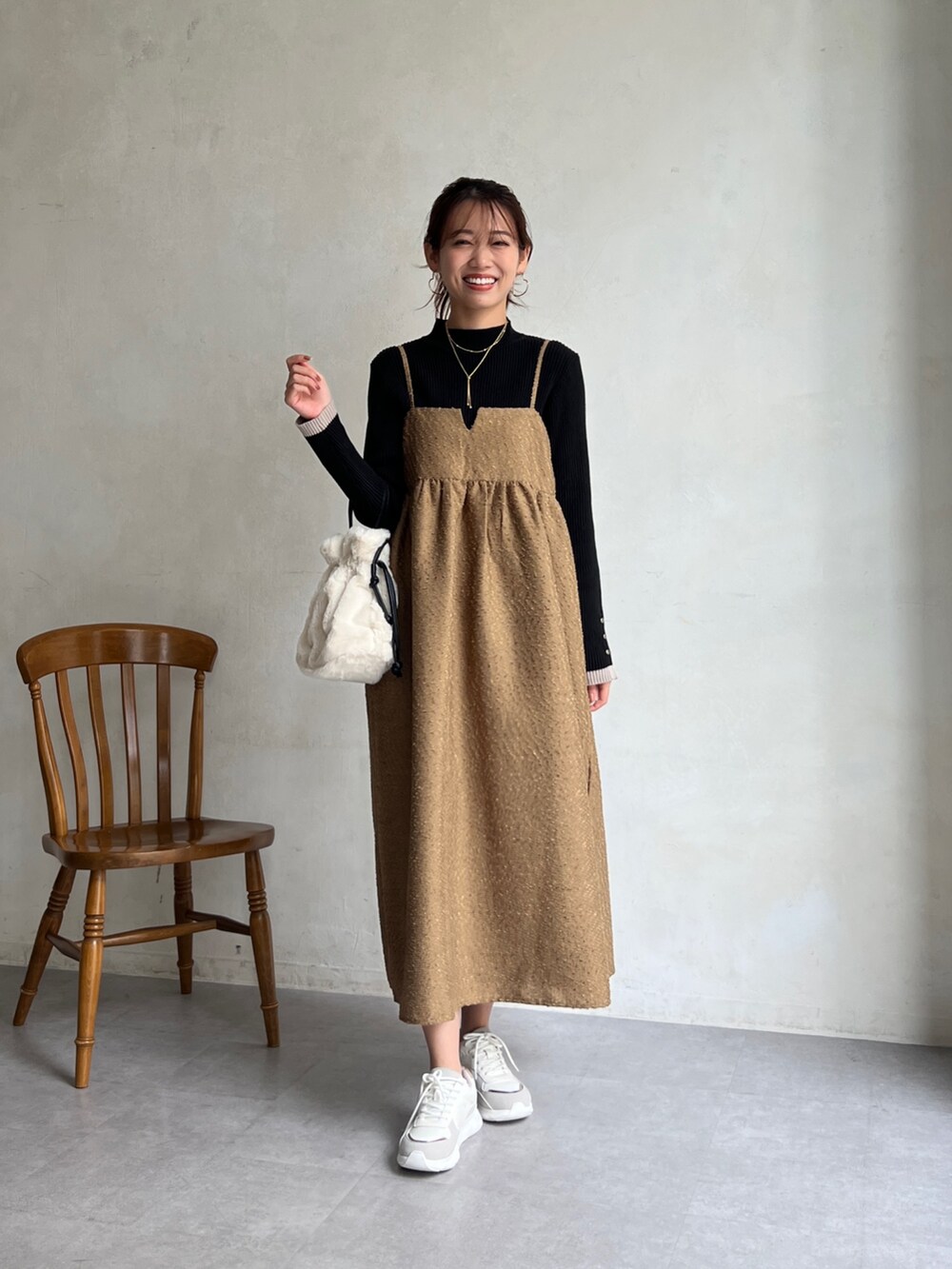 ブラウン系のワンピース、ブラック系のニット/セーター、ホワイト系のトートバッグを着用したレディースの冬コーディネートの5枚目の写真