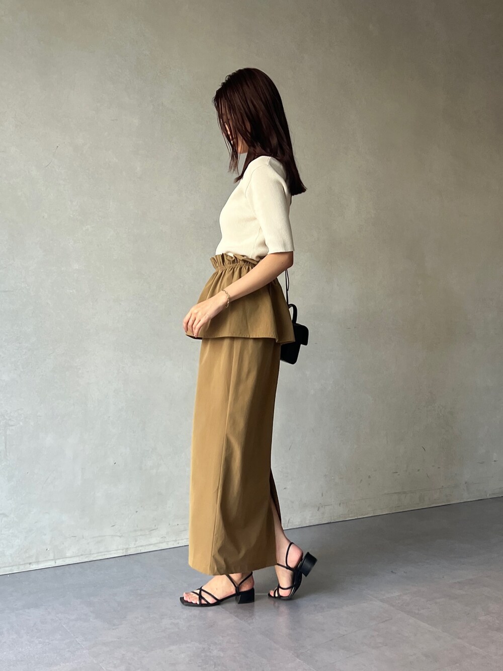 ホワイト系のニット/セーター、イエロー系のスカートを着用したレディースの夏コーディネートの2枚目の写真