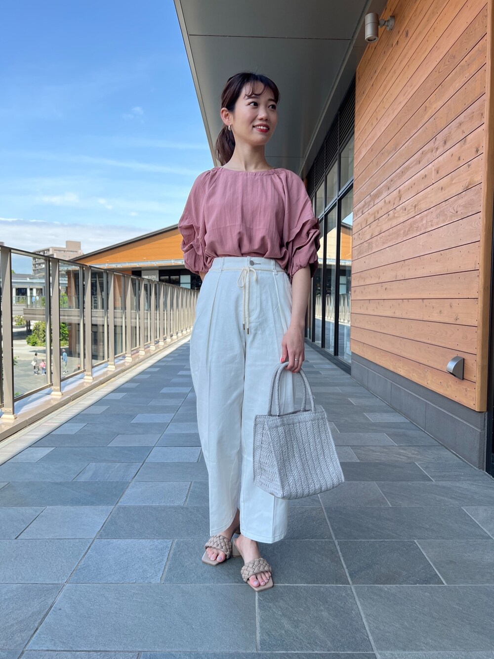 ホワイト系のシャツ/ブラウス、ホワイト系のその他パンツ、グレー系のかごバッグを着用したレディースの春コーディネートの2枚目の写真