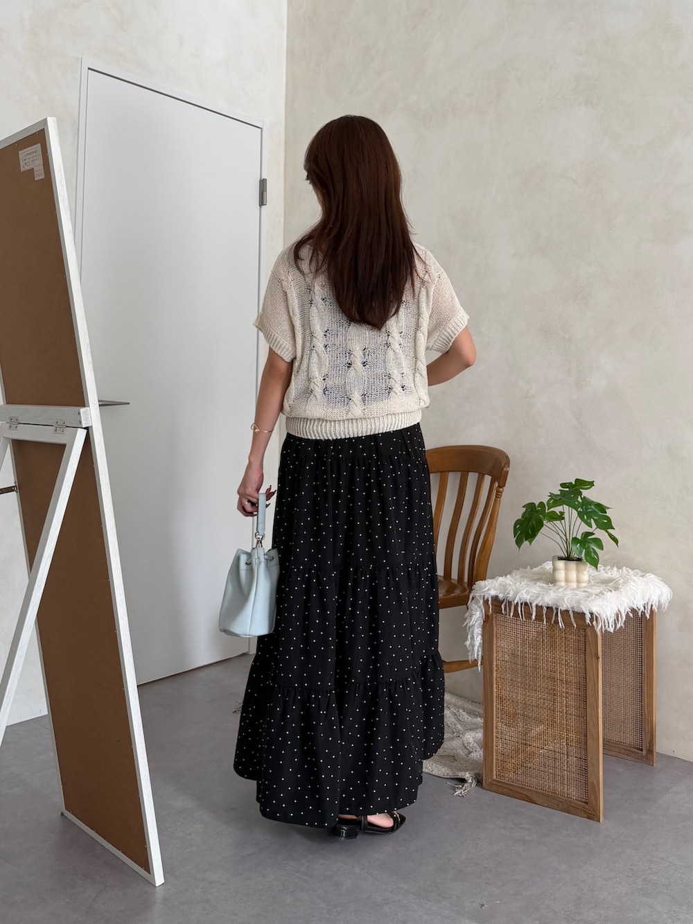 ホワイト系のニット/セーター、ブラック系のワンピース、ブラック系のサンダルを着用したレディースの春コーディネートの3枚目の写真