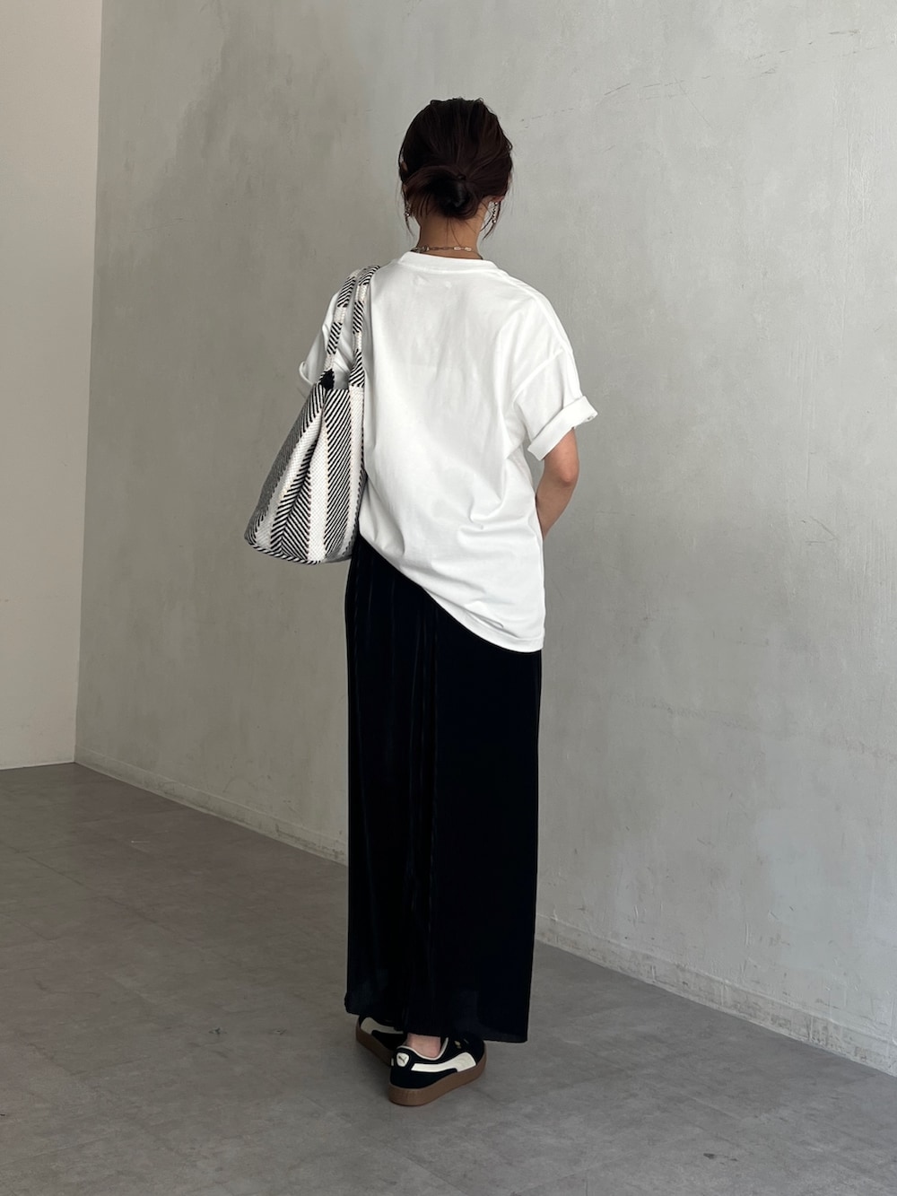 ホワイト系のTシャツ/カットソー、ブラック系のトートバッグ、ブラック系のスカートを着用したレディースの夏コーディネートの3枚目の写真