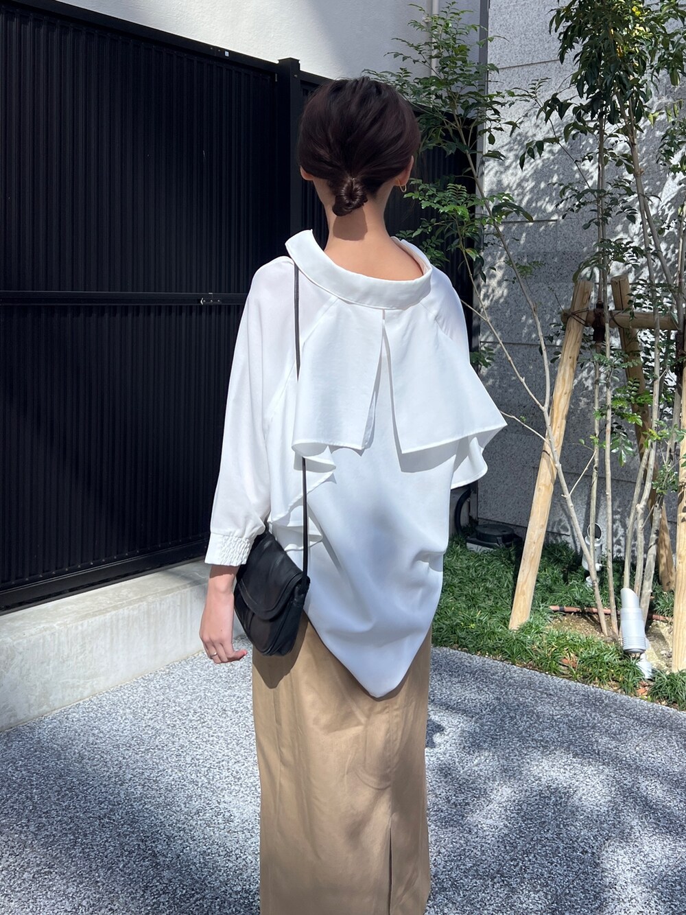 ホワイト系のシャツ/ブラウス、ベージュ系のスカート、ブラック系のサンダルを着用したレディースの春コーディネートの2枚目の写真