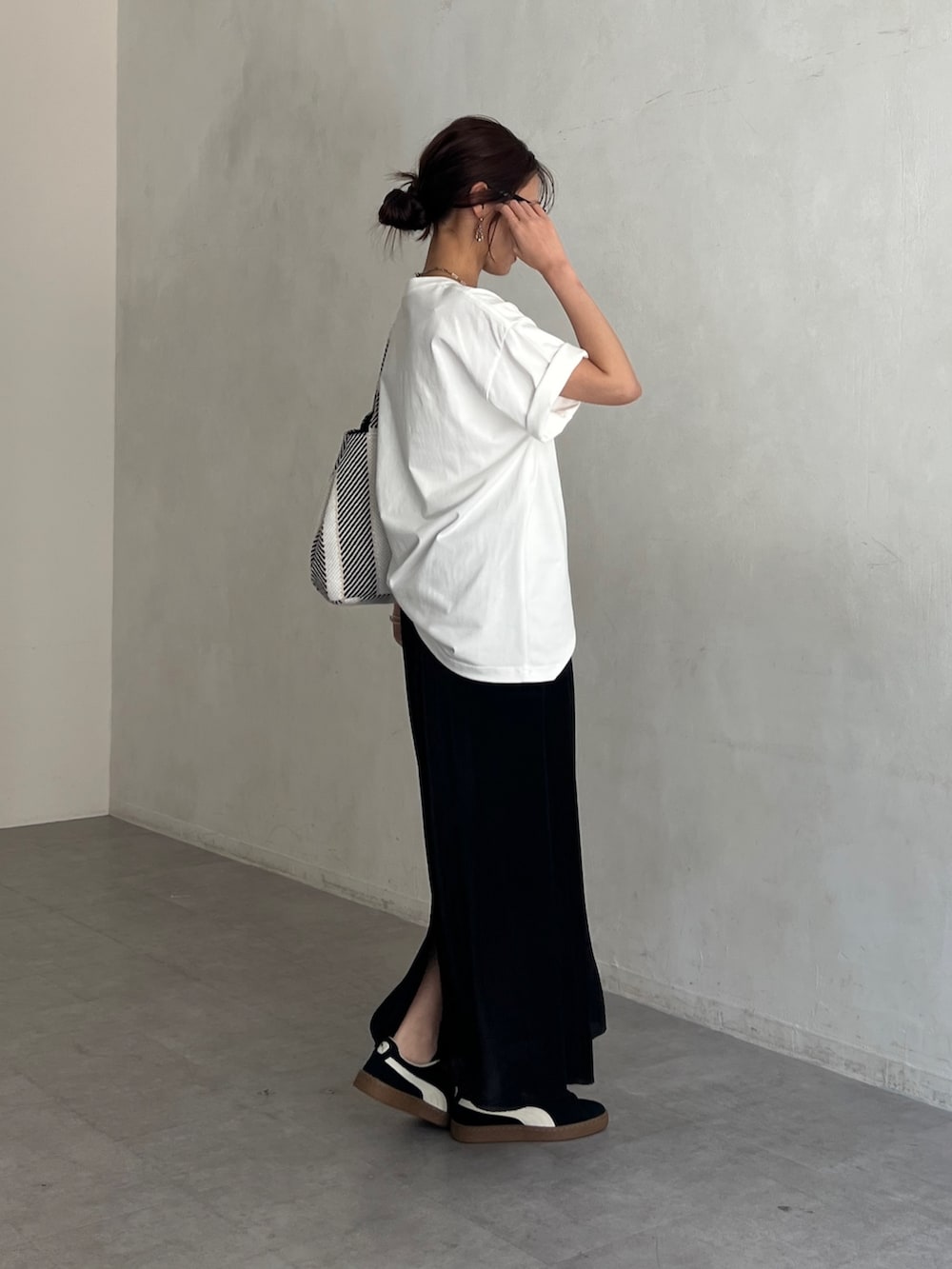 ホワイト系のTシャツ/カットソー、ブラック系のトートバッグ、ブラック系のスカートを着用したレディースの夏コーディネートの2枚目の写真