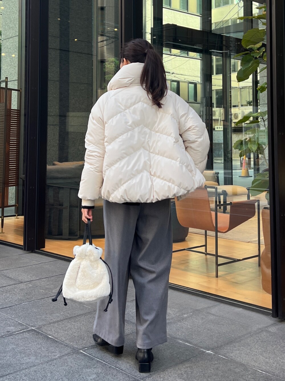 ホワイト系のダウンジャケット/コート、ホワイト系のニット/セーター、グレー系のその他パンツを着用したレディースの冬コーディネートの2枚目の写真