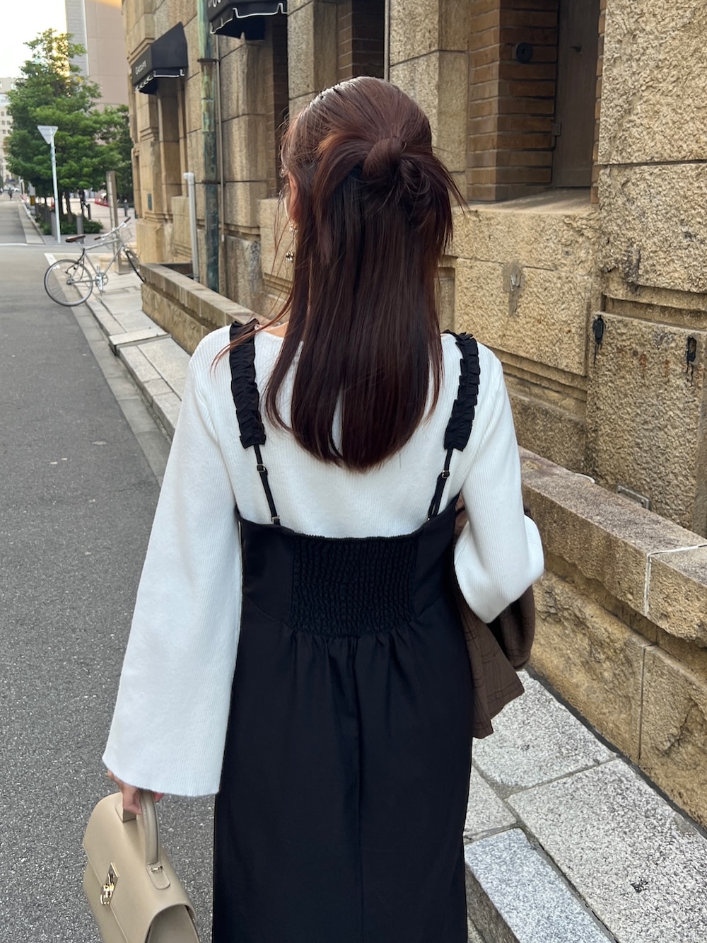 ブラウン系のテーラードジャケット、ブラック系のワンピース、ブラック系のブーツを着用したレディースの秋コーディネートの5枚目の写真