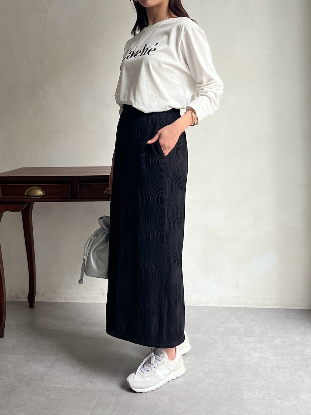 ホワイト系のTシャツ/カットソー、ブラック系のスカート、シルバー系のショルダーバッグを着用したレディースの春コーディネートの2枚目の写真