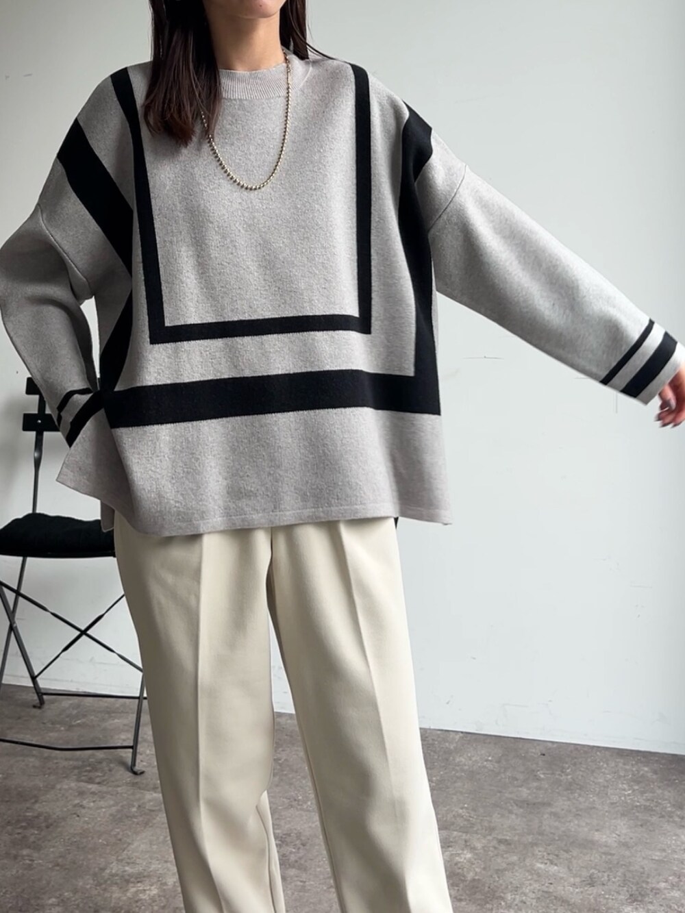 グレー系のニット/セーター、ホワイト系のその他パンツ、ブラック系のブーツを着用したレディースの秋コーディネートの3枚目の写真