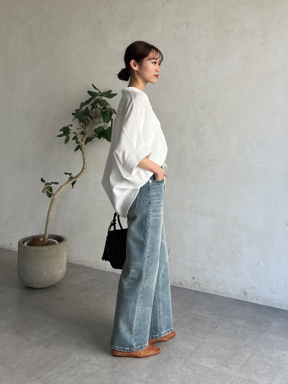 ホワイト系のシャツ/ブラウス、ブルー系のデニムパンツ、ブラック系のかごバッグを着用したレディースの春コーディネートの2枚目の写真