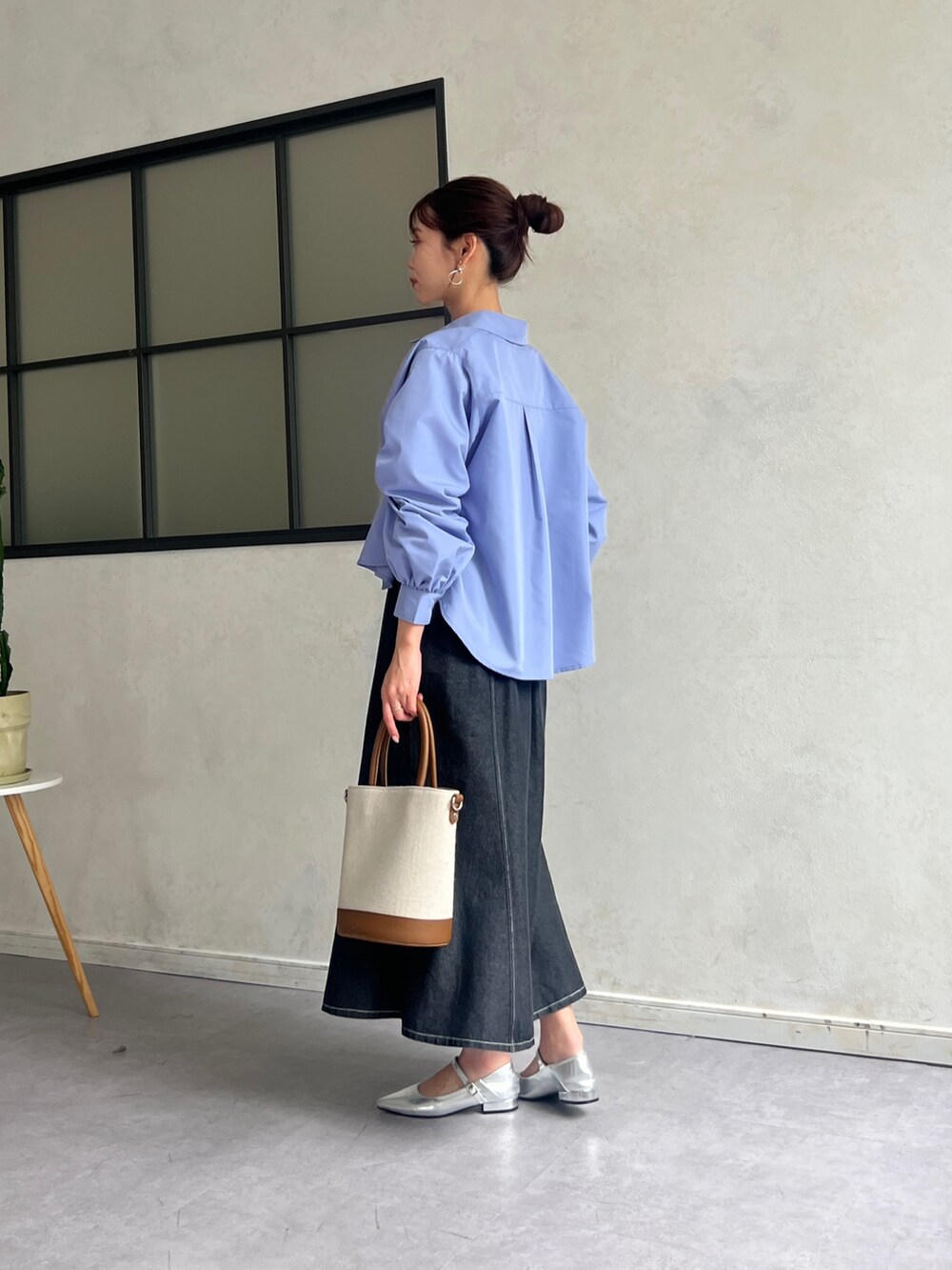 ブルー系のシャツ/ブラウス、ホワイト系のニット/セーター、ブラック系のスカートを着用したレディースの春コーディネートの3枚目の写真