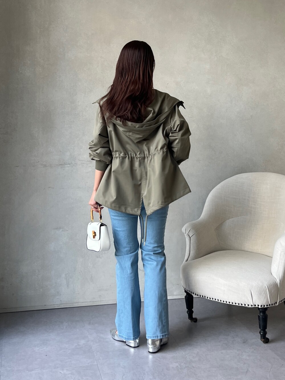 グリーン系のブルゾン、ホワイト系のシャツ/ブラウス、ブルー系のデニムパンツを着用したレディースの冬コーディネートの4枚目の写真