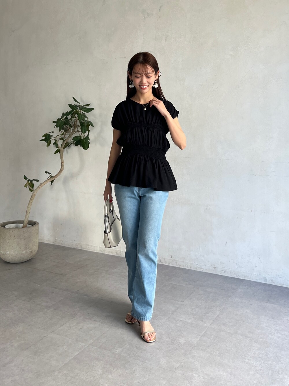 ブラック系のシャツ/ブラウス、ブルー系のデニムパンツを着用したレディースの春コーディネートの5枚目の写真