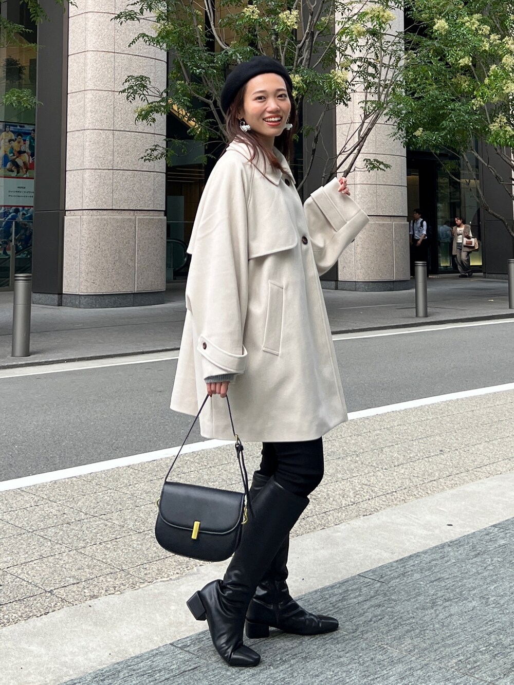 グレー系のニット/セーター、ホワイト系のその他アウター、ブラック系のその他パンツを着用したレディースの秋コーディネートの3枚目の写真