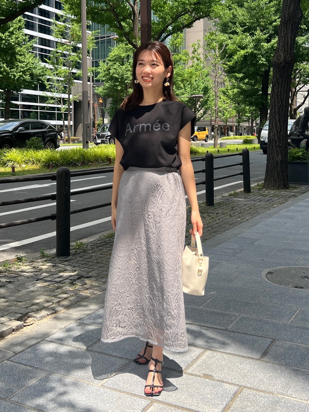 ブラック系のTシャツ/カットソー、グレー系のスカート、ホワイト系のショルダーバッグを着用したレディースの夏コーディネートの2枚目の写真