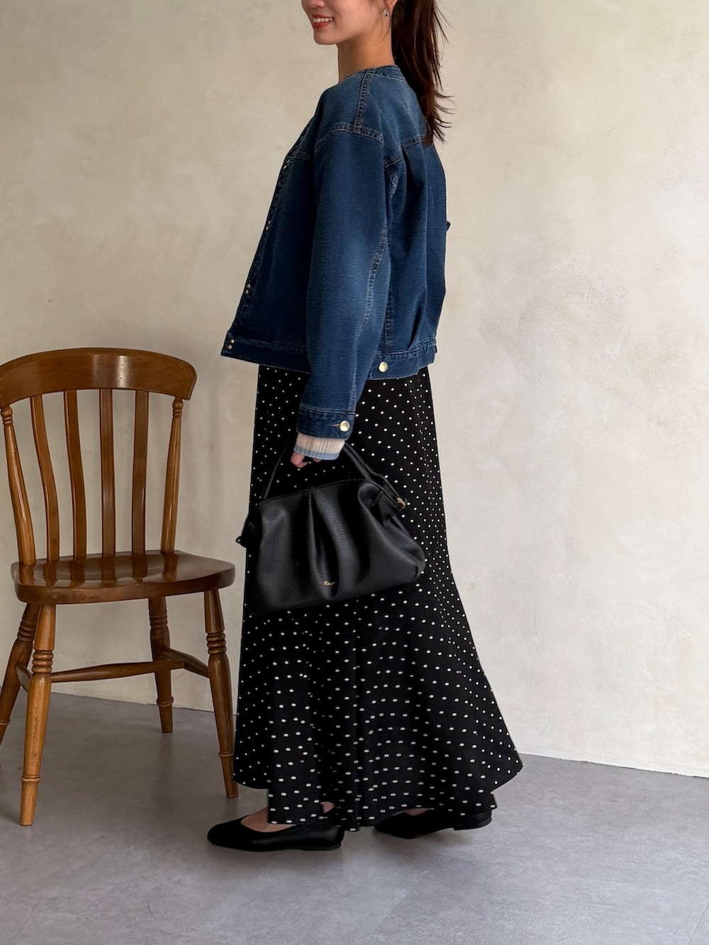 ブルー系のブルゾン、ブルー系のニット/セーター、ブラック系のスカートを着用したレディースの春コーディネートの2枚目の写真