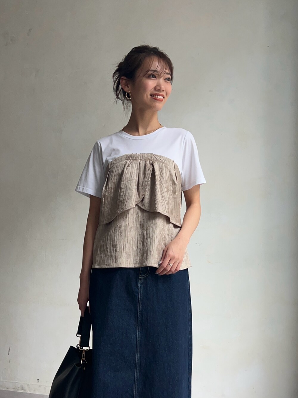 ベージュ系のTシャツ/カットソー、ブルー系のデニムスカート、ブラック系のシューズを着用したレディースの春コーディネートの5枚目の写真