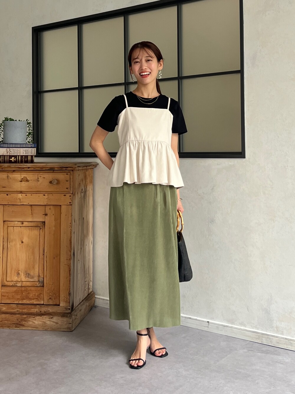 ホワイト系のワンピース、ブラック系のTシャツ/カットソー、グリーン系のスカートを着用したレディースの春コーディネートの4枚目の写真