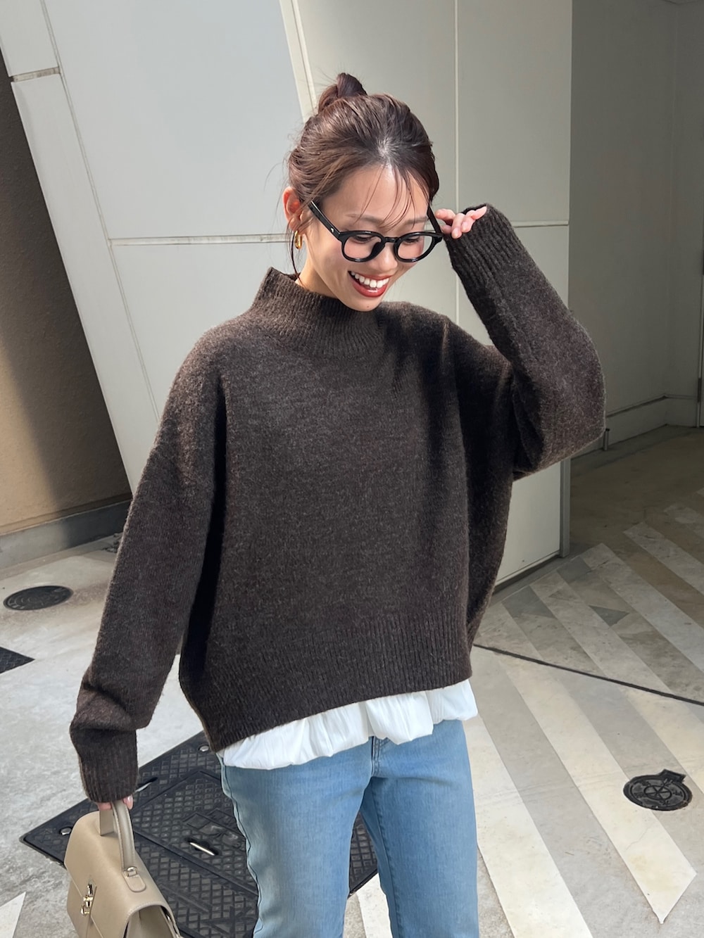 ブラウン系のニット/セーター、グレー系のカーディガン/ボレロ、ブルー系のデニムパンツを着用したレディースの秋コーディネートの2枚目の写真