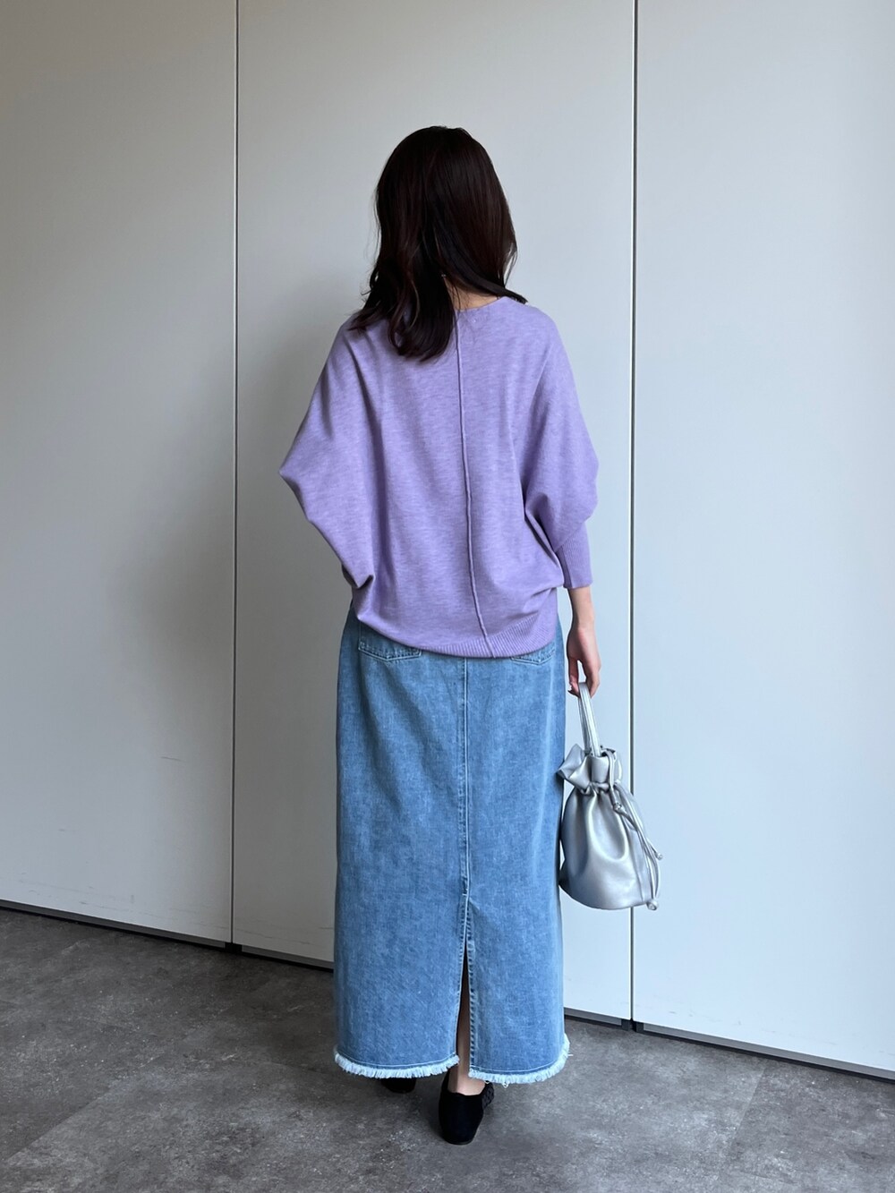 パープル系のニット/セーター、ブルー系のスカート、シルバー系のショルダーバッグを着用したレディースの冬コーディネートの2枚目の写真