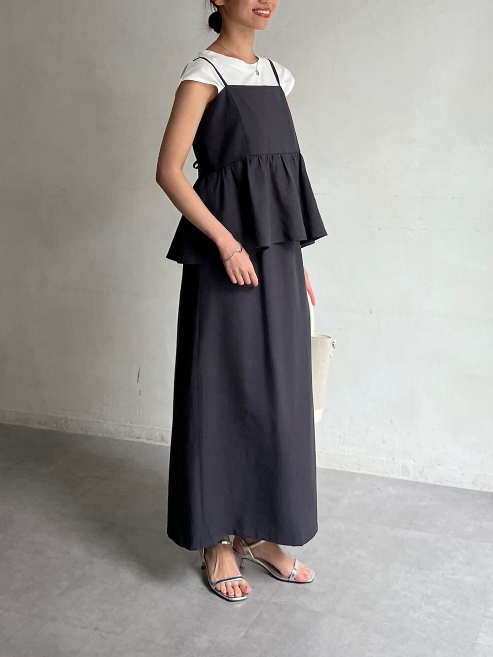 グレー系のワンピース、ホワイト系のトートバッグ、シルバー系のサンダルを着用したレディースの春コーディネートの2枚目の写真