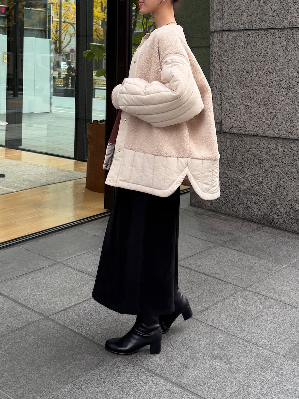 ホワイト系のニット/セーター、ホワイト系のその他アウター、ブラウン系のつなぎ/オールインワンを着用したレディースの冬コーディネートの2枚目の写真