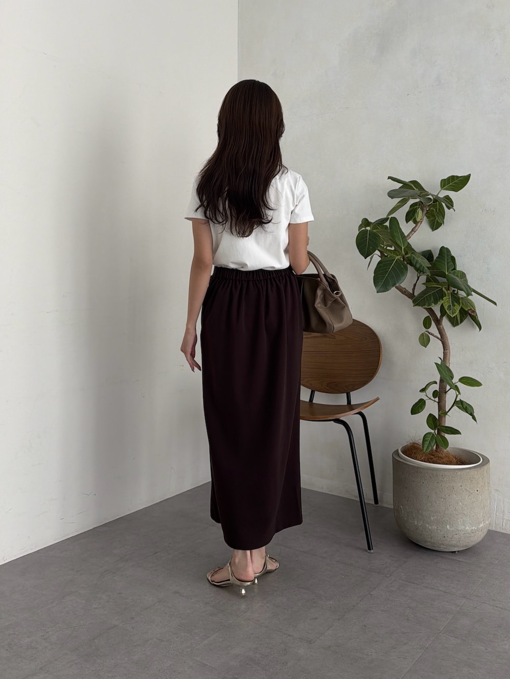 ホワイト系のTシャツ/カットソー、ブラウン系のスカート、ベージュ系のボストンバッグを着用したレディースの夏コーディネートの3枚目の写真