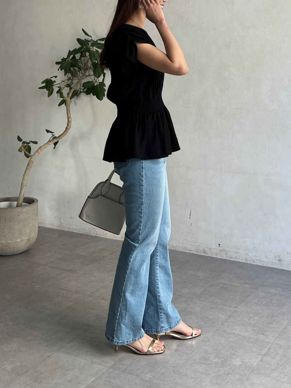 ブラック系のシャツ/ブラウス、ブルー系のデニムパンツを着用したレディースの春コーディネートの2枚目の写真