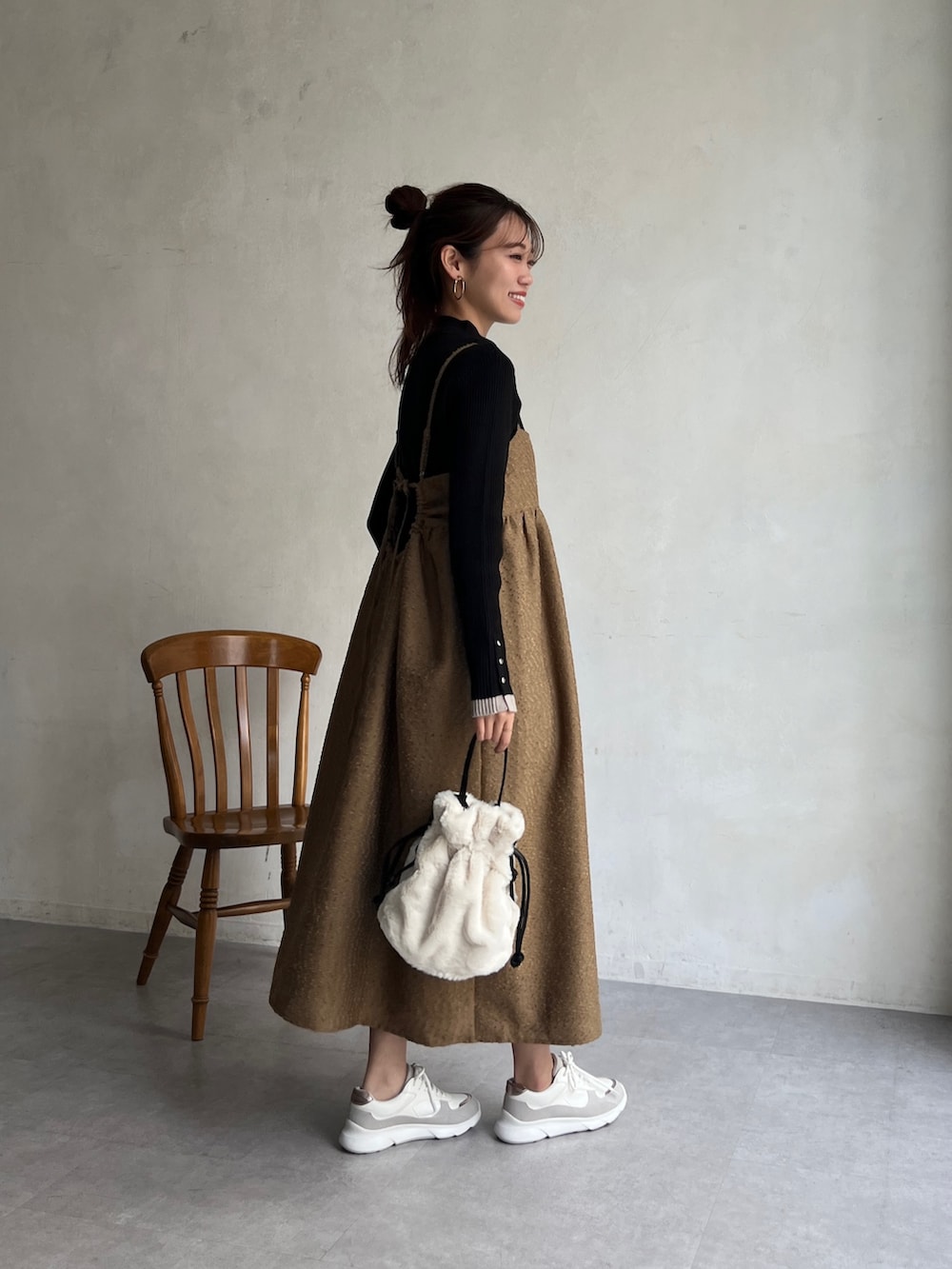 ブラウン系のワンピース、ブラック系のニット/セーター、ホワイト系のトートバッグを着用したレディースの冬コーディネートの4枚目の写真