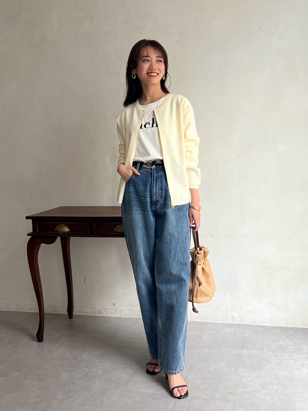 ホワイト系のカーディガン/ボレロ、ホワイト系のTシャツ/カットソー、ブルー系のデニムパンツを着用したレディースの春コーディネートの2枚目の写真