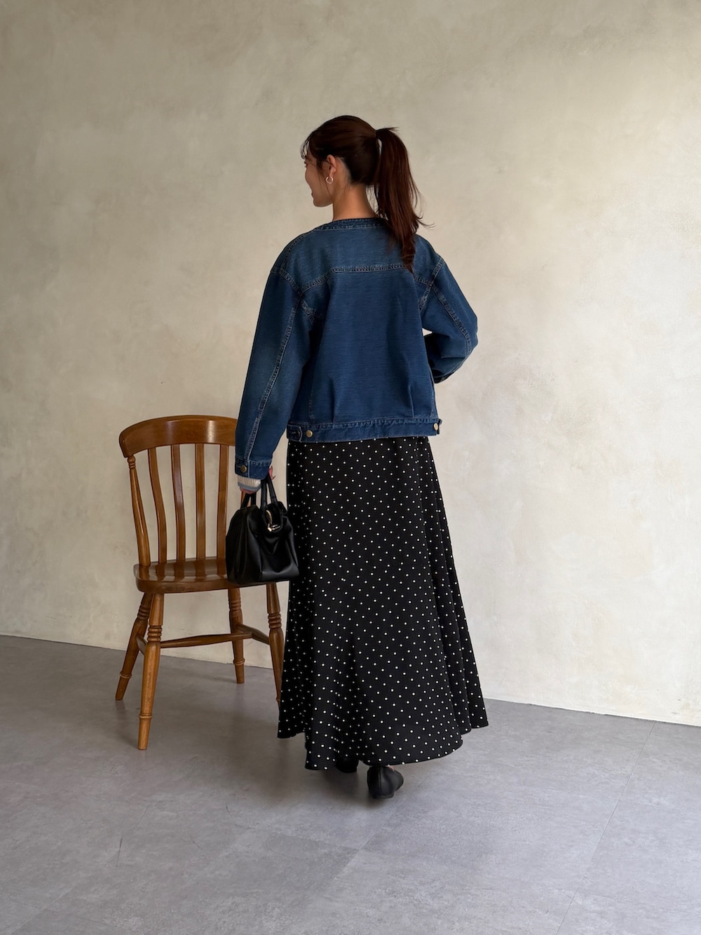 ブルー系のブルゾン、ブルー系のニット/セーター、ブラック系のスカートを着用したレディースの春コーディネートの3枚目の写真