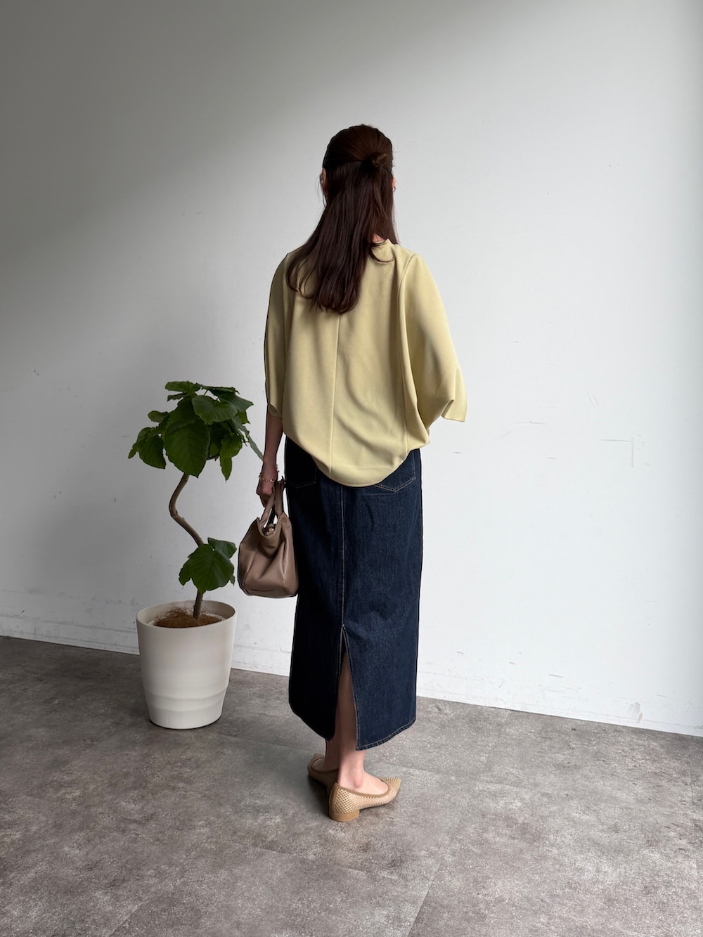 グリーン系のTシャツ/カットソー、ブルー系のスカート、ベージュ系のボストンバッグを着用したレディースの春コーディネートの4枚目の写真