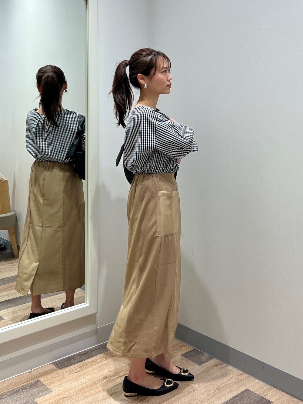 ブラック系のシャツ/ブラウス、ブラック系のショルダーバッグ、イエロー系のスカートを着用したレディースの春コーディネートの2枚目の写真