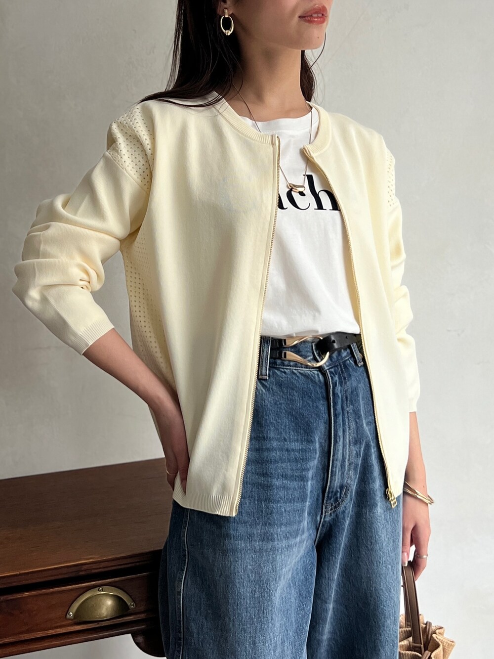 ホワイト系のカーディガン/ボレロ、ホワイト系のTシャツ/カットソー、ブルー系のデニムパンツを着用したレディースの春コーディネートの3枚目の写真